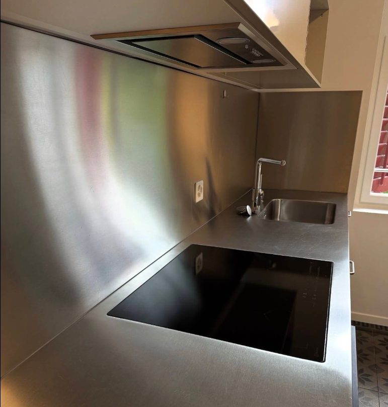 Küche mit Edelstahl-Arbeitsplatte und Kochfeld