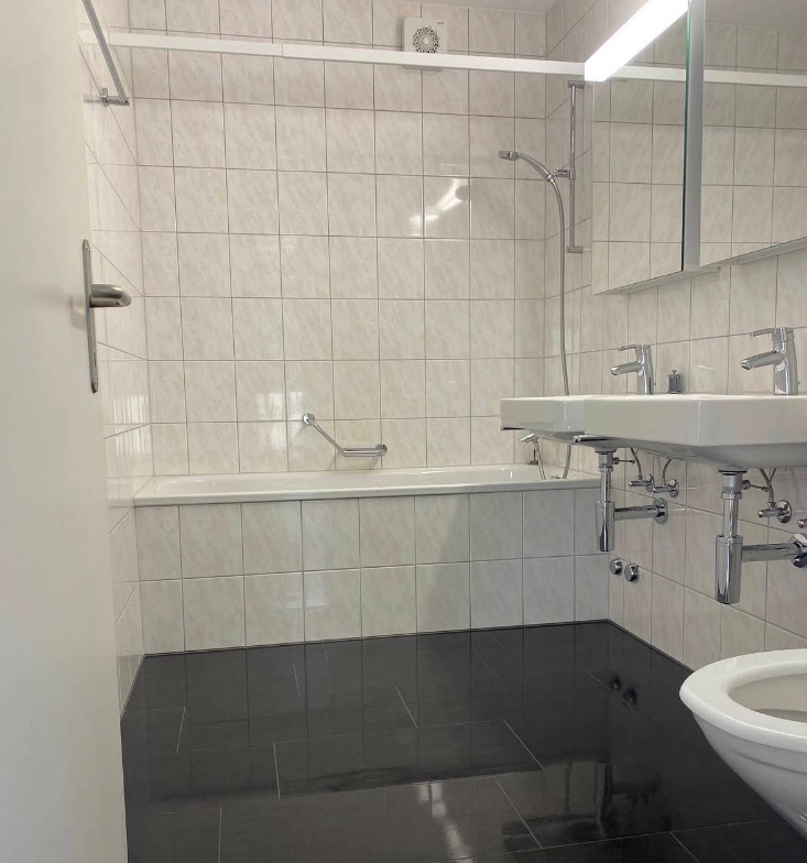 Helles Badezimmer mit Wanne und Doppelwaschtisch